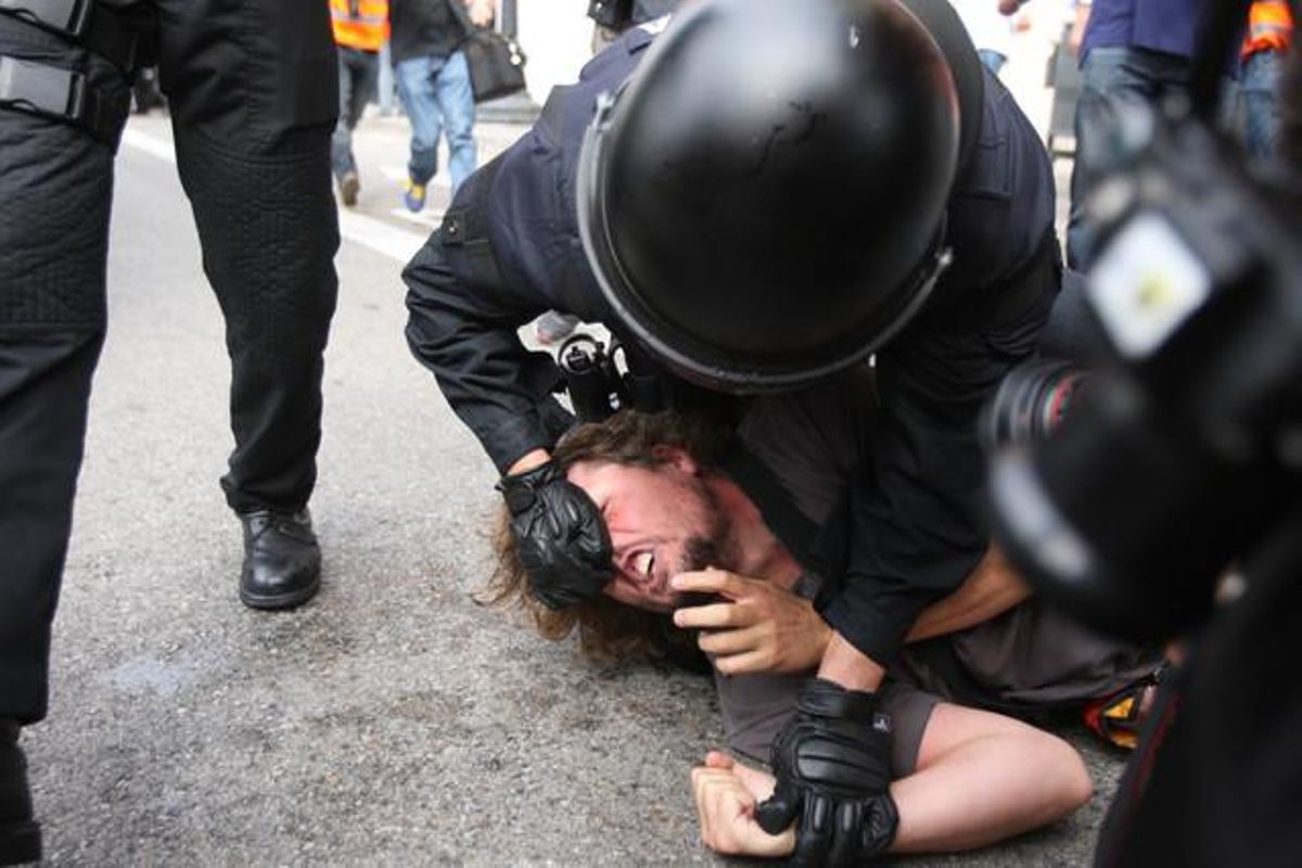 Un agente inmoviliza a uno de los ocupantes de la plaza de Catalunya de Barcelona, el 27 de mayo del 2011. Un agente inmoviliza a uno de los ocupantes de la plaza de Catalunya de Barcelona, el 27 de mayo del 2011.
