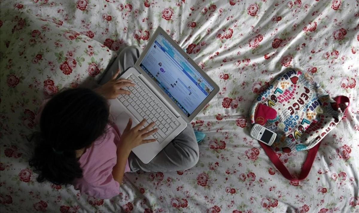 Una niña navega por internet desde su ordenador.