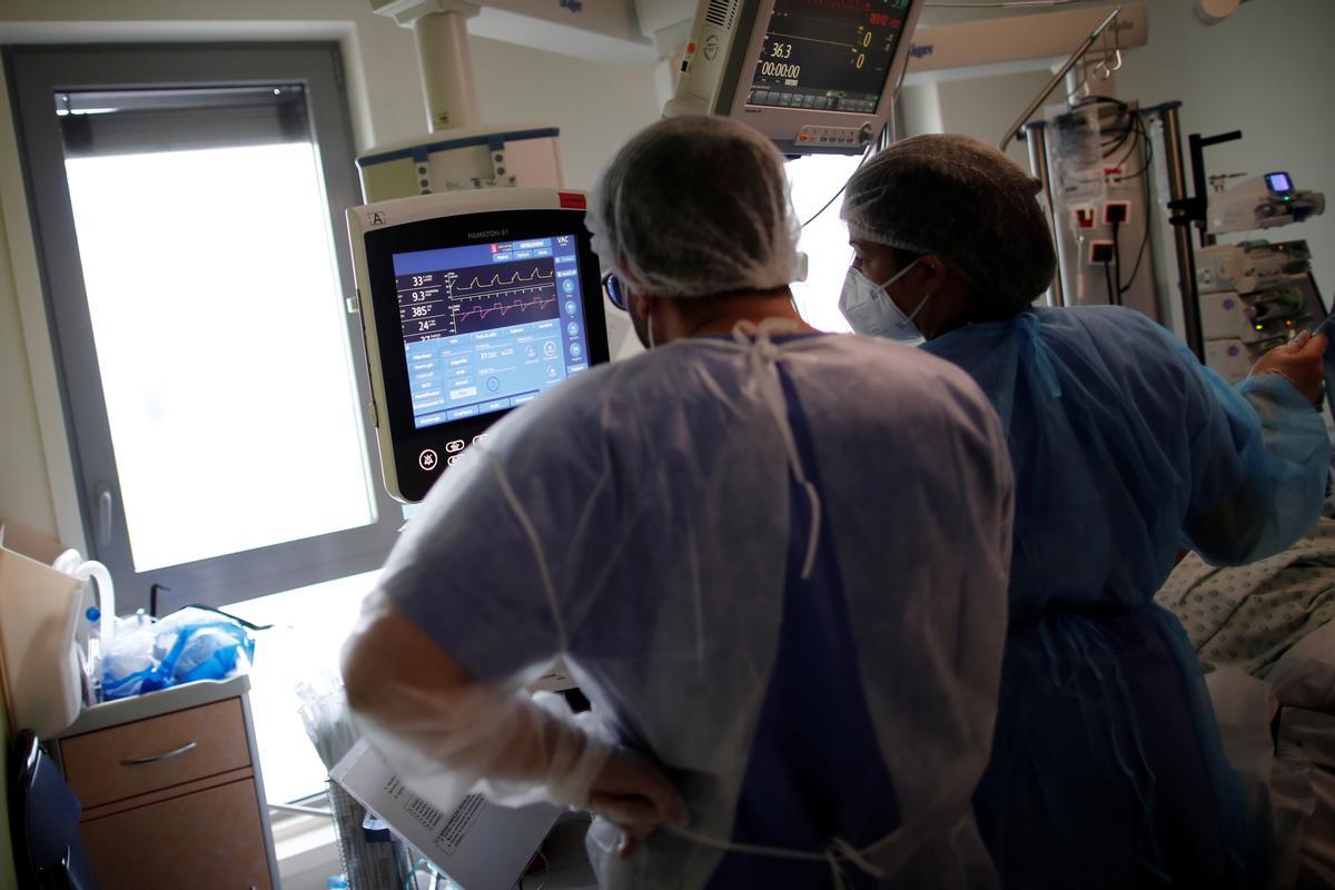 Dos trabajadores del hospital Melun-Senart, cerca de París, miran el monitor de un paciente de covid-19 ingresado en la uci.