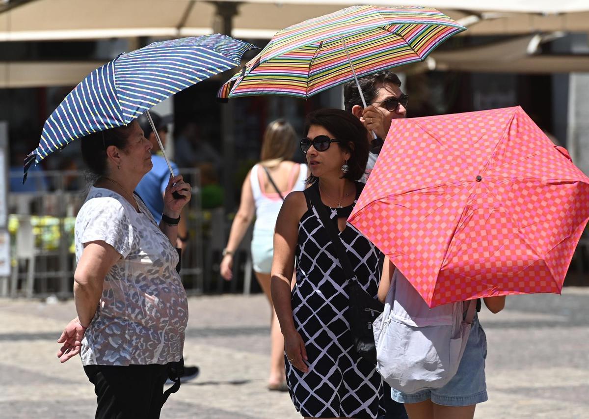 Varias personas paseaban ayer con sombrilla por el centro de Madrid. EFE/Fernando Villar