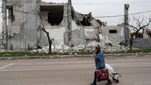 Una mujer pasa frente a un edificio destruido en Mariúpol.