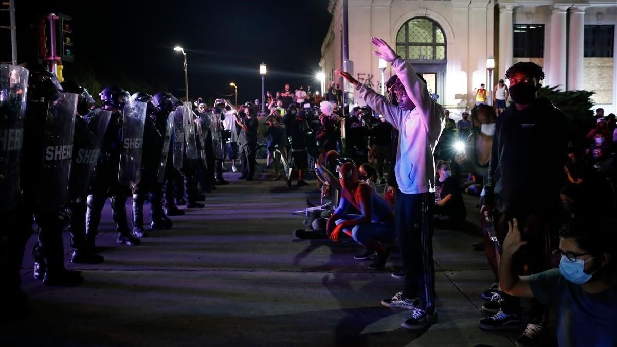 Manifestantes se encaran con la policía durante las protestas contra la violencia racial, la pasada madrugada en Kenosha. Manifestantes se encaran con la policía durante las protestas contra la violencia racial, la pasada madrugada en Kenosha.