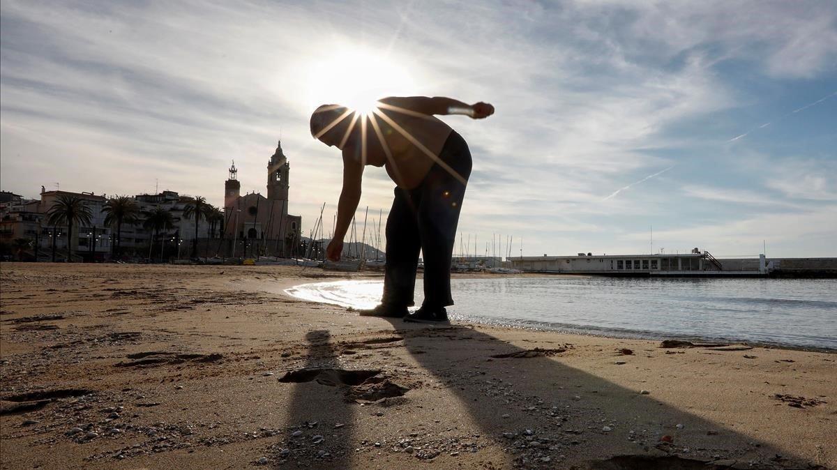 Un hombre hace ejercicio en la playa de Sitges.