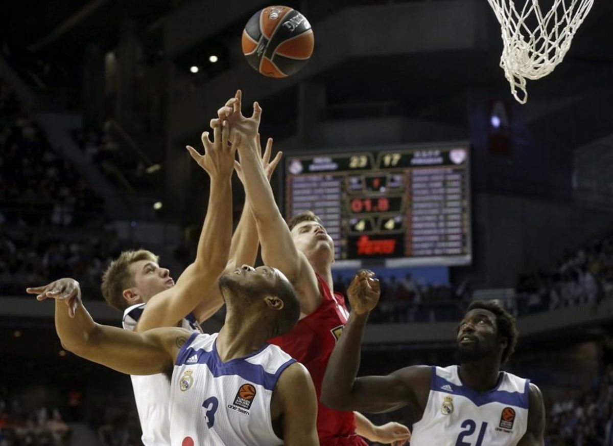 Doncic, Randolph y Hunter luchan por un balón con Agravanis. Doncic, Randolph y Hunter luchan por un balón con Agravanis.