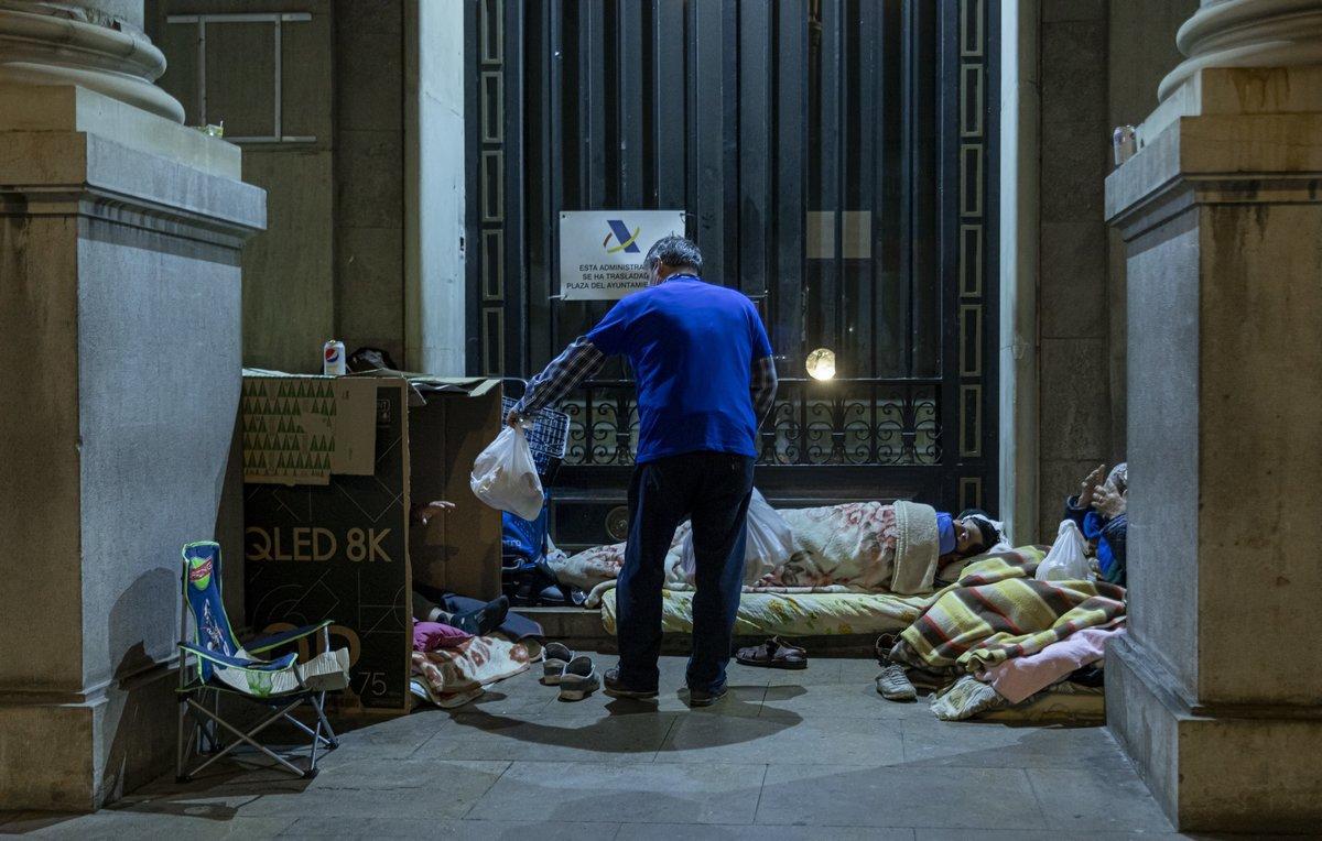 Confinados en la calle. Un voluntario reparte comida a personas sin hogar durante el estado de alarma.