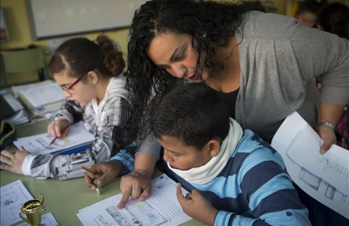 Una madre ayuda a un alumno de primaria en la comunidad de aprendizaje del colegio Joaquim Ruyra de L’Hospitalet de Llobregat. Una madre ayuda a un alumno de primaria en la comunidad de aprendizaje del colegio Joaquim Ruyra de L’Hospitalet de Llobregat.