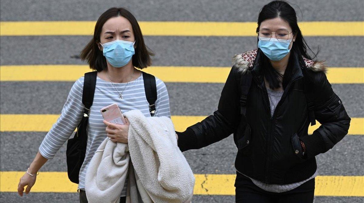 Dos mujeres con máscara, como prevención frente al brote de coronavirus, en Hong Kong.