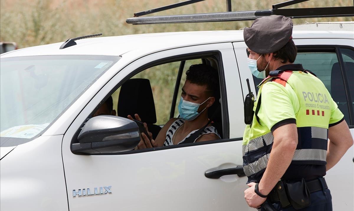 Un mosso detiene a un vehículo en el marco de los controles de movilidad habilitados en la entrada de Soses y otros municipios de Lleida por el rebrote del coronavirus.