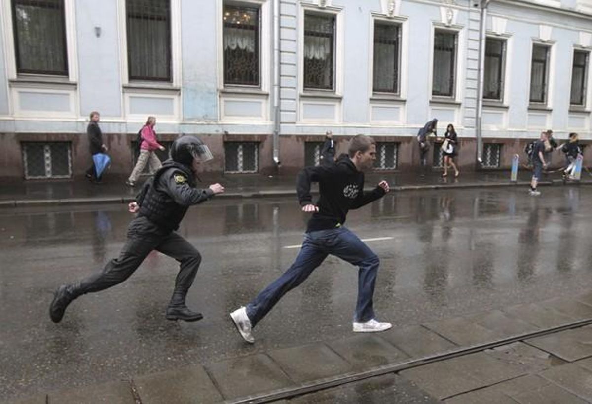Un policía antidisturbios persigue a un joven que participaba en una manifestación contra el nombramiento de Vladimir Putin en Moscú. Un policía antidisturbios persigue a un joven que participaba en una manifestación contra el nombramiento de Vladimir Putin en Moscú.