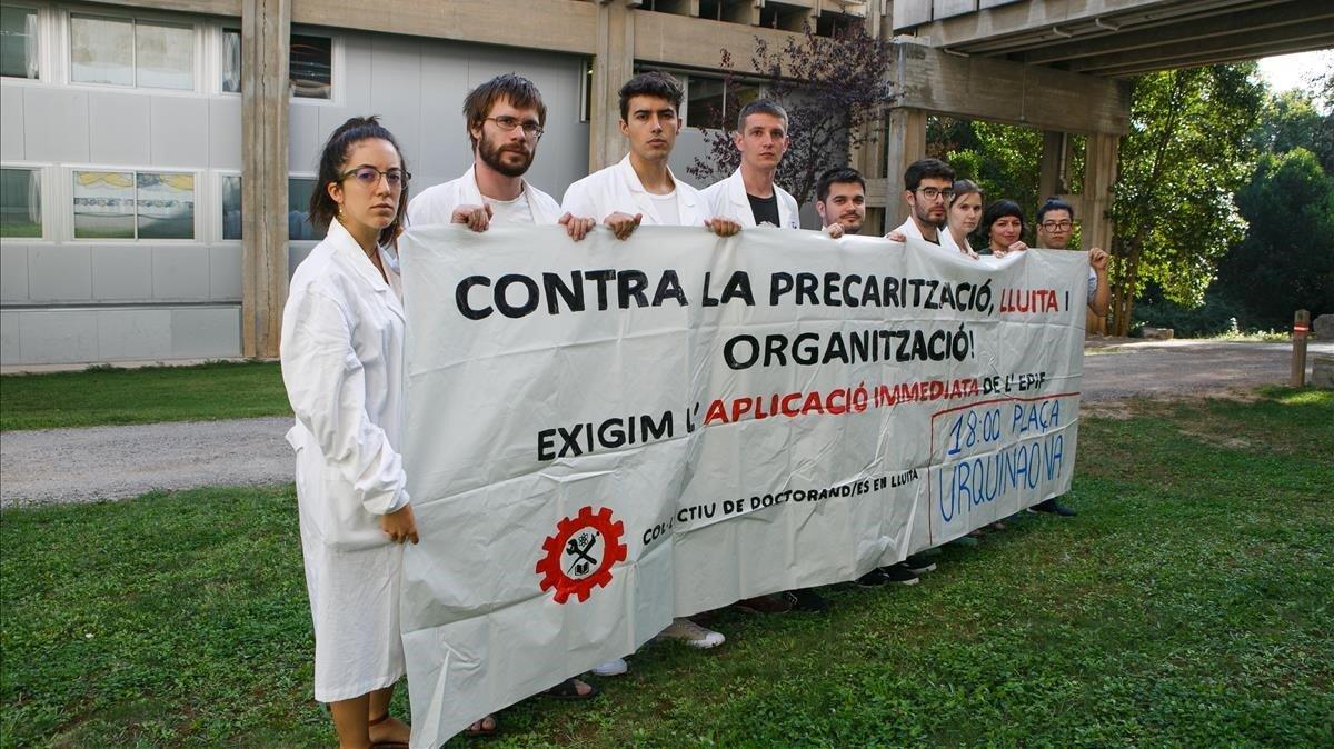 Un grupo de doctorandos sostienen una pancarta que llama a manifestarse por sus derechos, el pasado mes de septiembre. Un grupo de doctorandos sostienen una pancarta que llama a manifestarse por sus derechos, el pasado mes de septiembre.