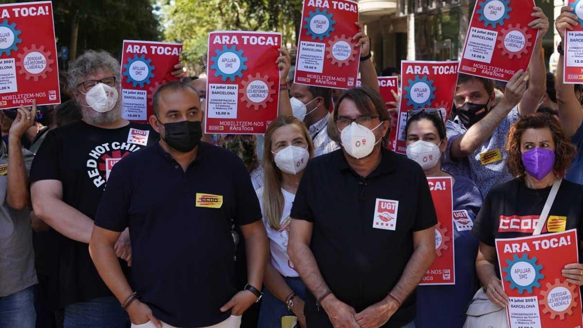 Los líderes de CCOO y UGT de Catalunya, Javier Pacheco (izquierda) y Camil Ros (derecha) protestan frente a la Delegación del Gobierno en Barcelona para exigir la subida del salario mínimo. 