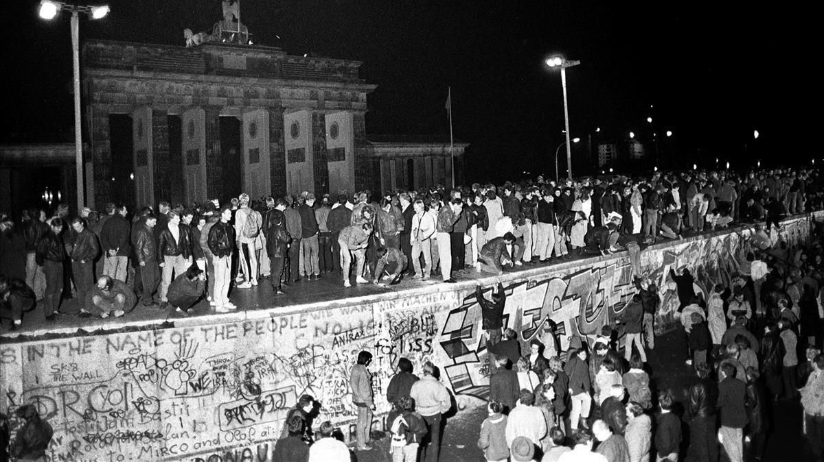 Ciudadanos de Berlín Este y Berlín Oeste celebran sobre el muro el fin de la división de la ciudad, el 9 de noviembre de 1989. Ciudadanos de Berlín Este y Berlín Oeste celebran sobre el muro el fin de la división de la ciudad, el 9 de noviembre de 1989.