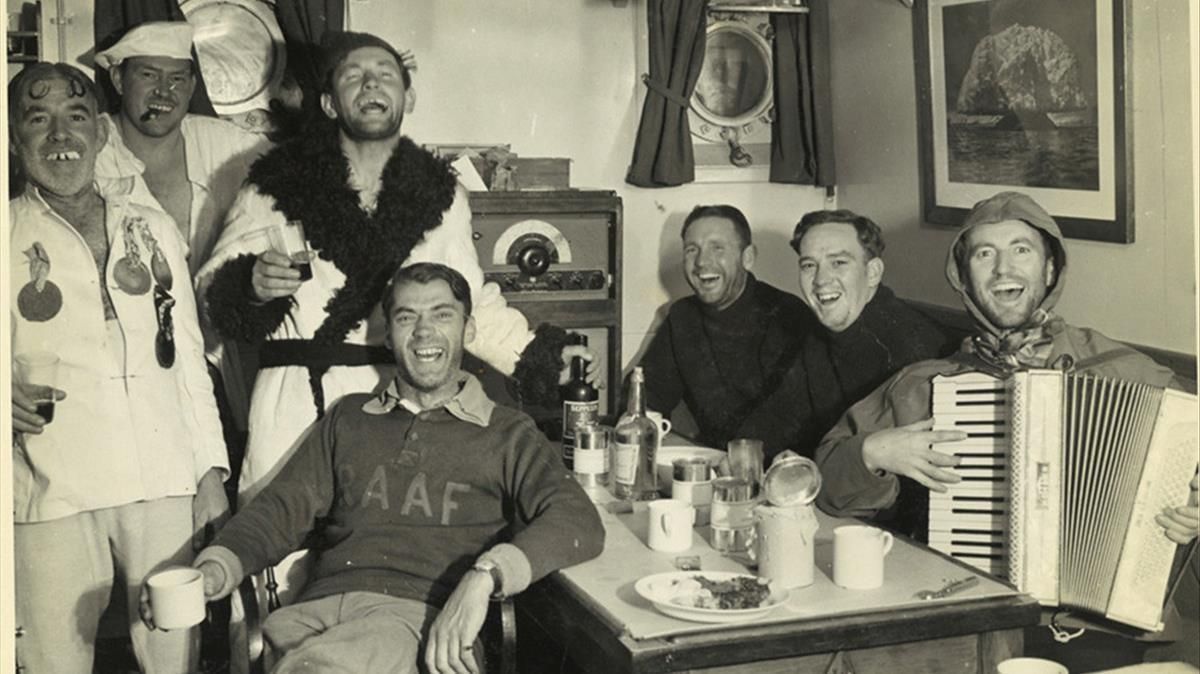 Oficiales y marineros del ’HMS Wyatt Earp’ cantan en la cámara del capitán, en febrero de 1948. Oficiales y marineros del ’HMS Wyatt Earp’ cantan en la cámara del capitán, en febrero de 1948.