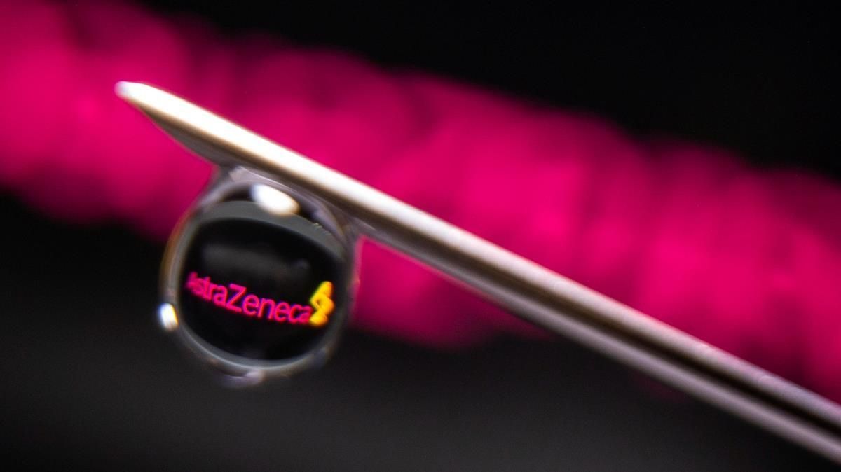 El logo de la farmacéutica AstraZeneca se refleja en una gota de una vacuna contra el covid-19. El logo de la farmacéutica AstraZeneca se refleja en una gota de una vacuna contra el covid-19.