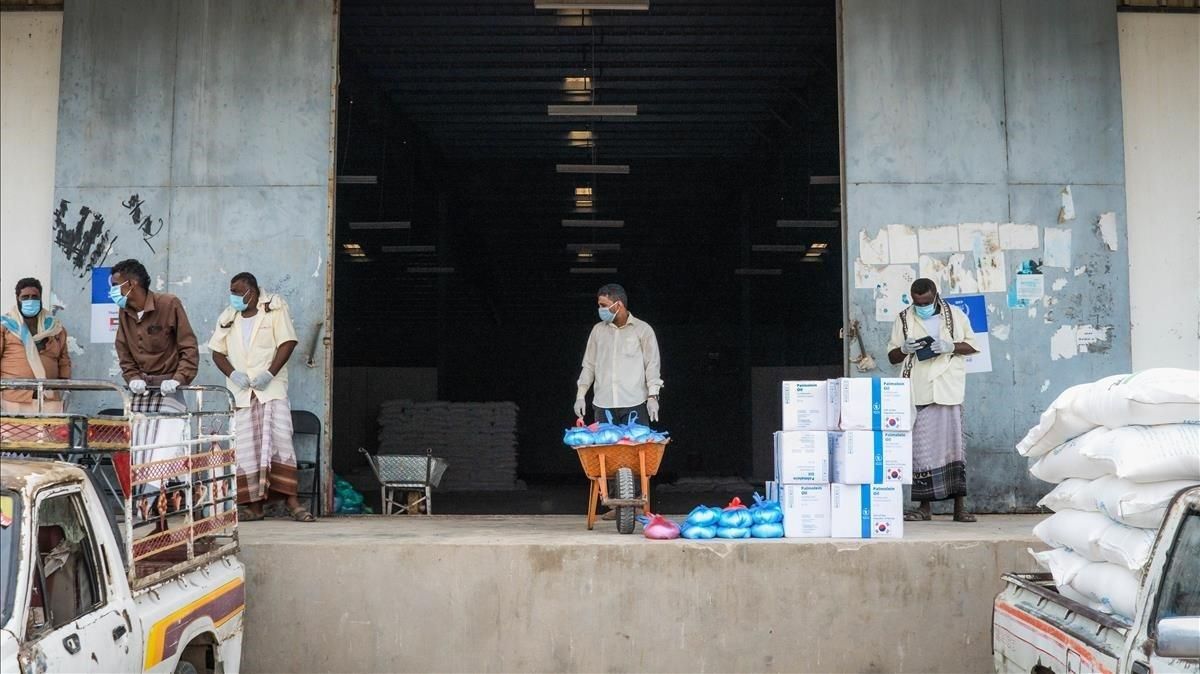 Unos trabajadores humanitarios llevan bolsas de comida a un camión que las distribuirá, en Abyan (Yemen). Unos trabajadores humanitarios llevan bolsas de comida a un camión que las distribuirá, en Abyan (Yemen).