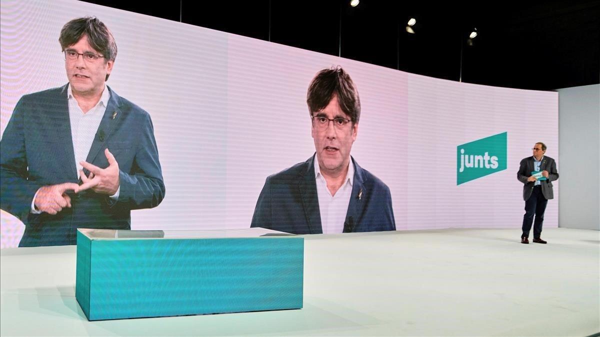Torra escucha la intervención por videoconferencia de Puigdemont, en el acto inaugural del congreso fundacional del nuevo Junts per Catalunya el pasado 25 de julio.