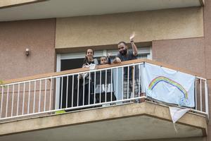 Una familia saluda desde su balcón durante el confinamiento por la crisis del coronavirus.