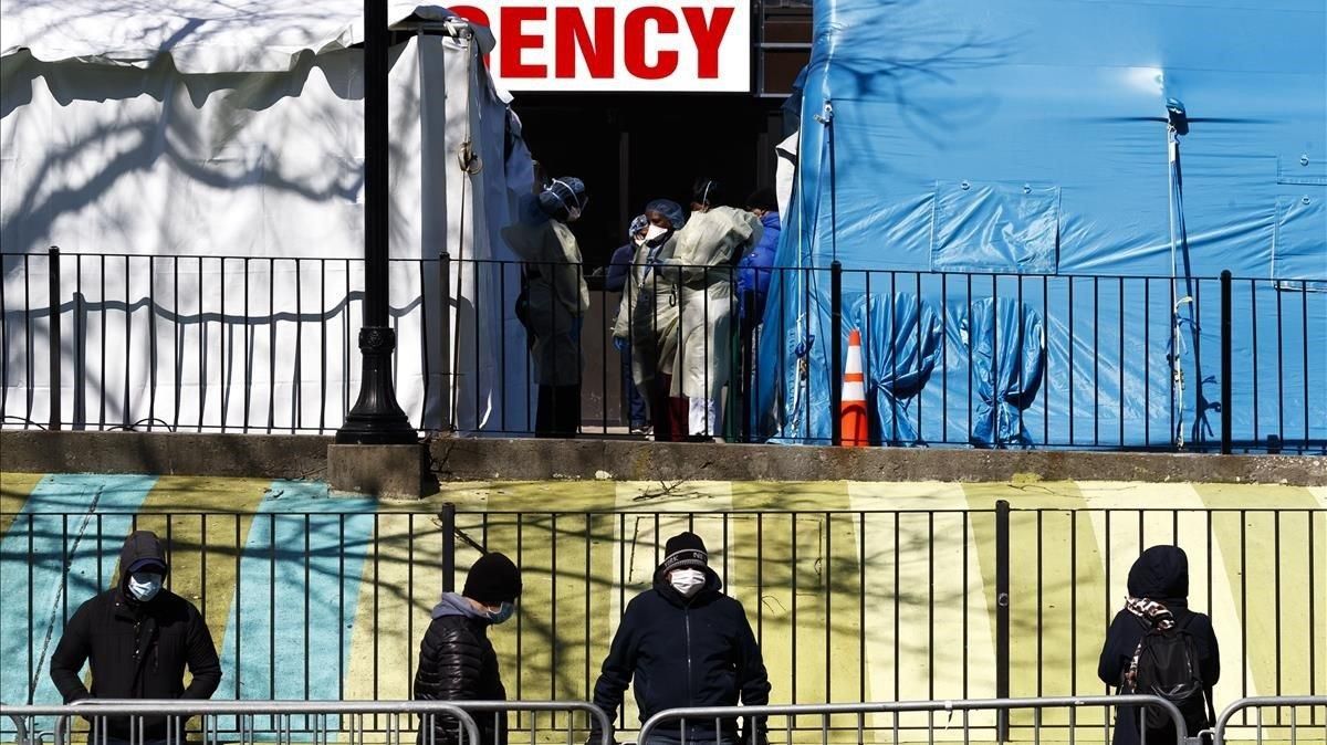 Un grupo de personas hace cola para hacerse la prueba del coronavirus en el hospital Elmhurst de Queens, en Nueva York. Un grupo de personas hace cola para hacerse la prueba del coronavirus en el hospital Elmhurst de Queens, en Nueva York.