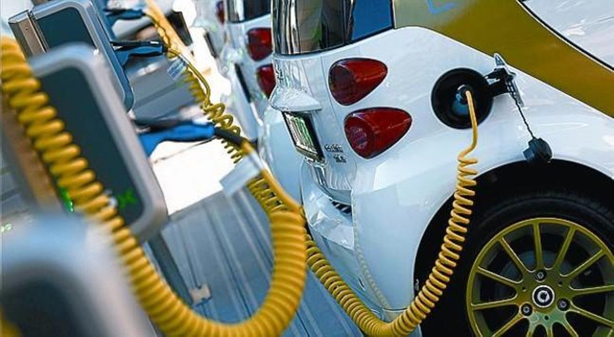 Coche eléctrico enchufado a un punto de carga. Coche eléctrico enchufado a un punto de carga.