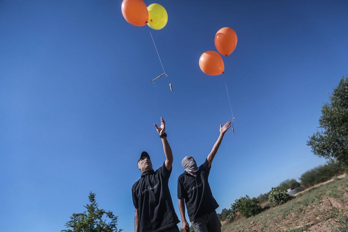 Un grupo de palestinos lanzan globos incendiarios desde Gaza con destino a Israel. Un grupo de palestinos lanzan globos incendiarios desde Gaza con destino a Israel.
