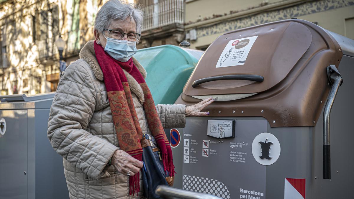 Una vecina de Sant Andreu estrena un nuevo contenedor de residuos orgánicos situado en la plaza de las Palmeres, este lunes
