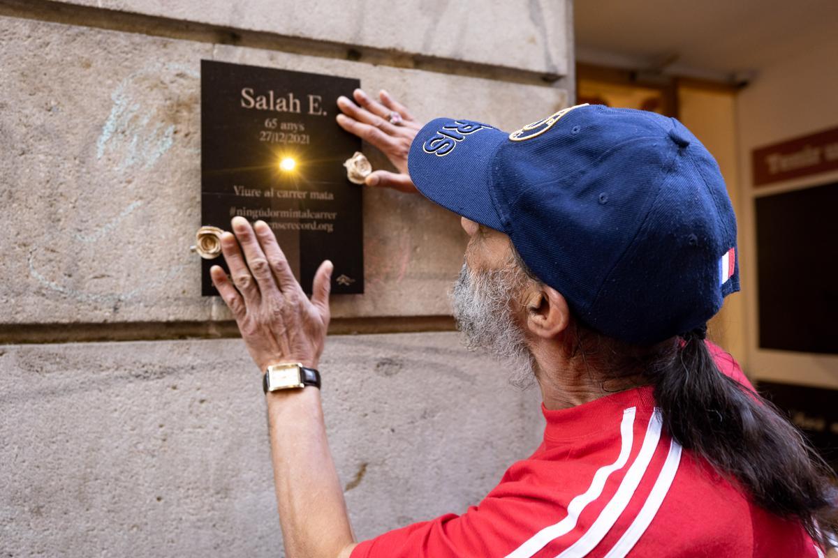 Alí coloca en la calle una placa en recuerdo a su amigo Salah, fallecido en 2021, en una acció por el recuerdo promovida por la fundación Arrels el pasado martes. 
