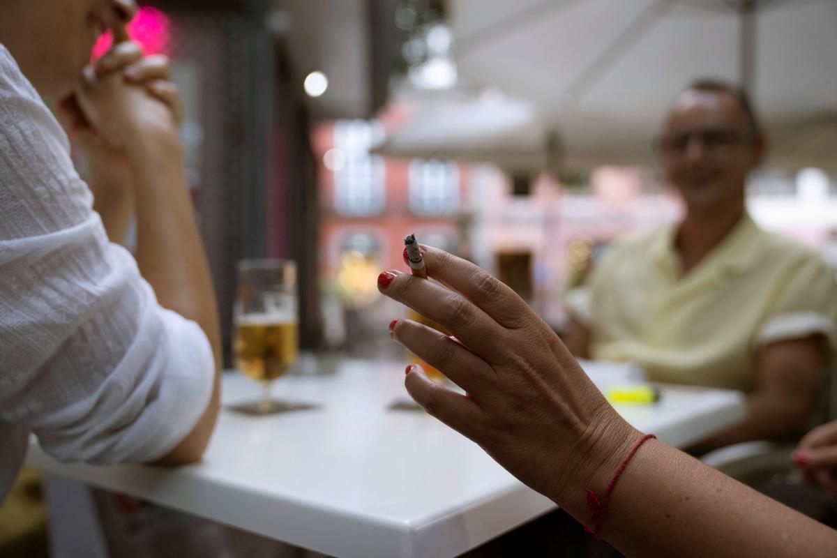 Una mujer sostiene un cigarrillo en la terraza de en un bar en Santa Cruz de Tenerife. EFE/Miguel Barreto/Archivo