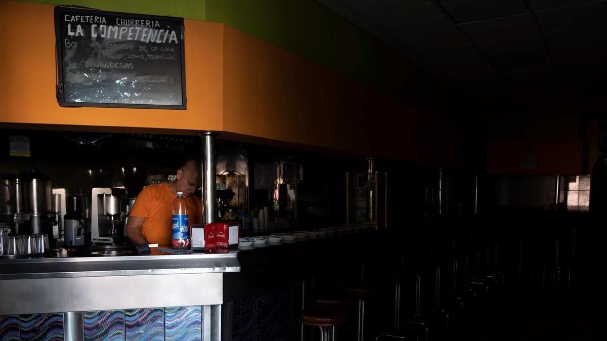 Un empleado de una cafetería de Santa Cruz de Tenerife intenta trabajar a oscuras mientras espera a que se restablezca el suministro eléctrico la isla. Un empleado de una cafetería de Santa Cruz de Tenerife intenta trabajar a oscuras mientras espera a que se restablezca el suministro eléctrico la isla.