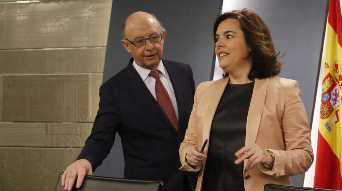 Montoro y Sáenz de Santamaría, en una rueda de prensa en la Moncloa. Montoro y Sáenz de Santamaría, en una rueda de prensa en la Moncloa.