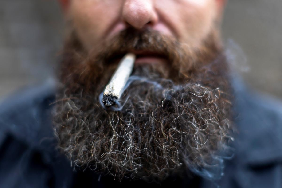 Un turista fuma cannabis después de comprarlo en el Highland Cafe el primer día de su eliminación de la lista de narcóticos