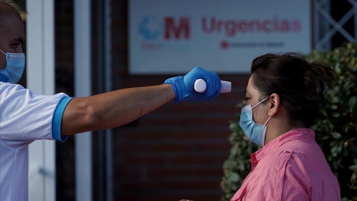 Un sanitario tomando la temperatura antes de hacer la prueba PCR, en San Sebastián de los Reyes Un sanitario tomando la temperatura antes de hacer la prueba PCR, en San Sebastián de los Reyes