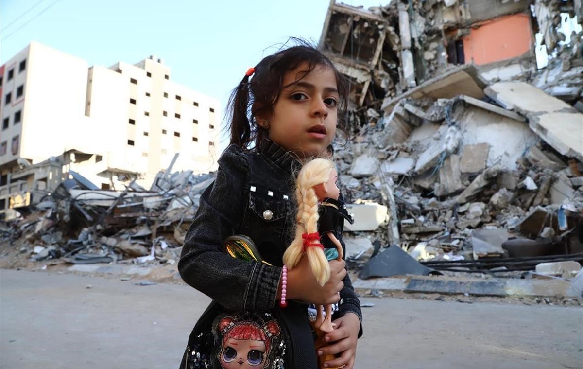 Una niña frente a unas casas destruidas tras un ataque aéreo israelí, en Gaza.