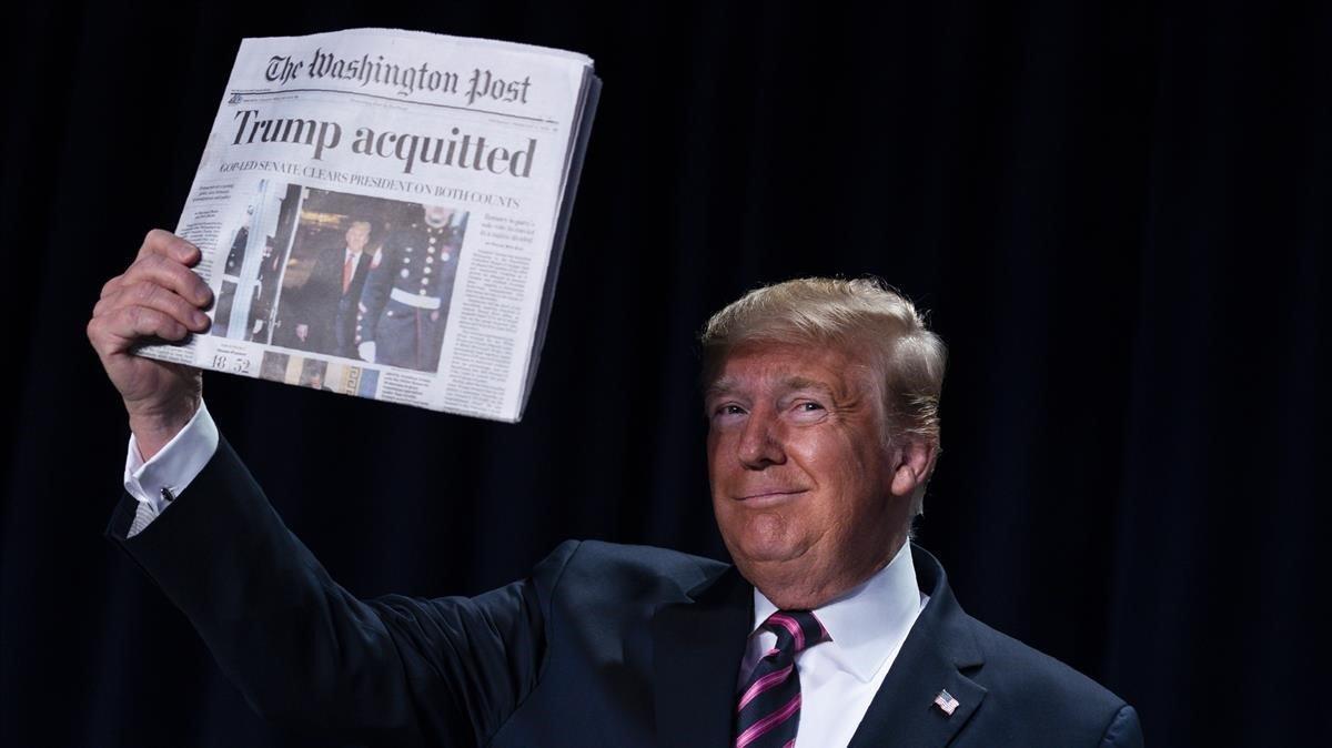 Donald Trump muestra un ejemplar de periódico. 