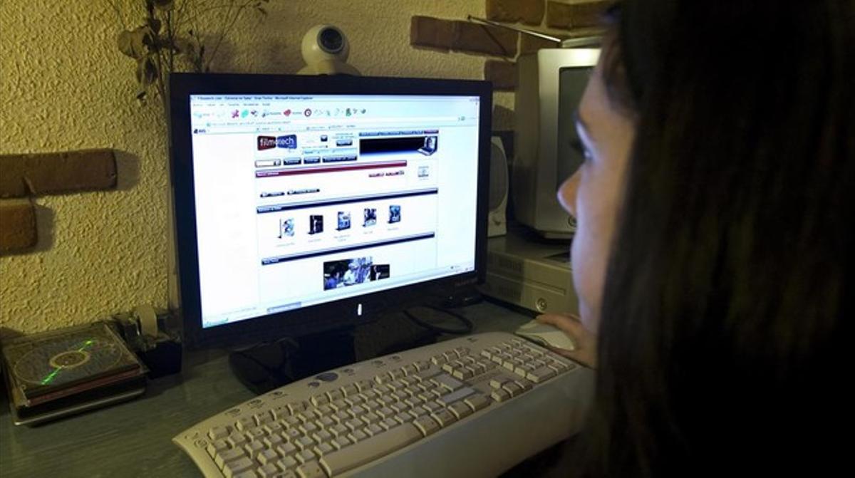 Una mujer consulta una página de descargas en internet.