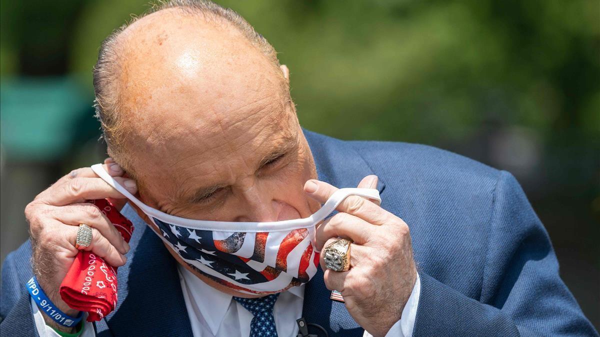 El abogado de Trump, Rudy Giuliani, poniéndose una mascarilla después de hablar en un acto en la Casa Blanca   