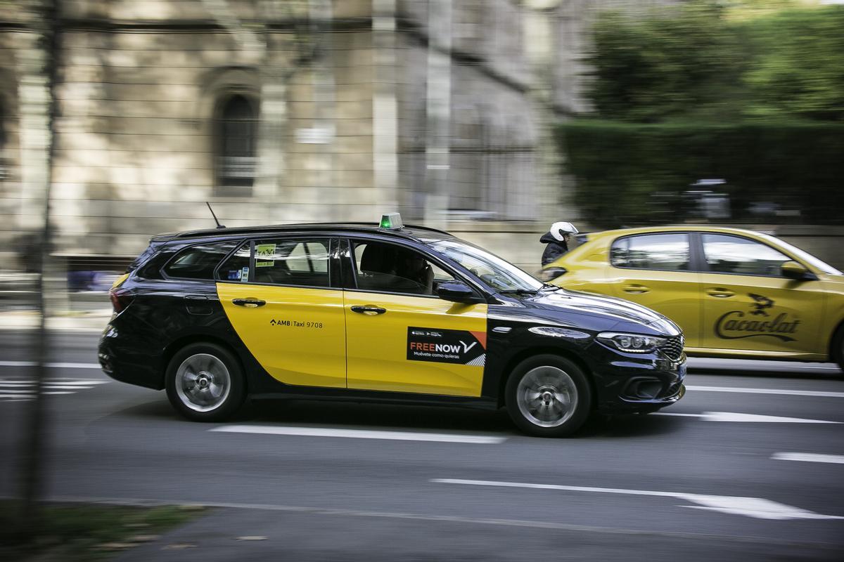 Un taxi circula por las calles de Barcelona con publicidad de Free Now en un lateral