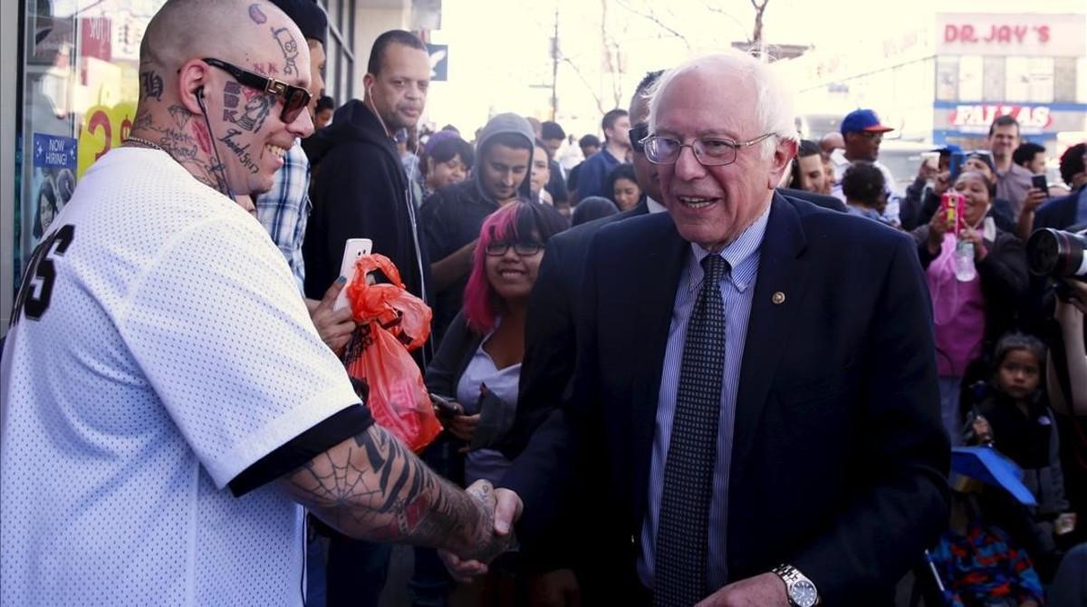 Sanders (izq), felicitado por un transeúnte en el Bronx, este lunes.