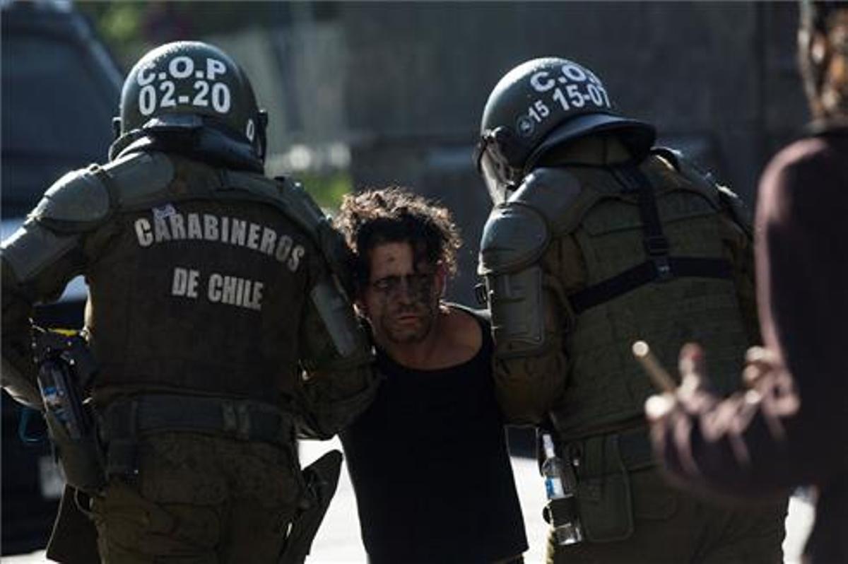 Carabineros detienen hoy a un manifestante durante una protesta junto al Palacio de La Moneda. Carabineros detienen hoy a un manifestante durante una protesta junto al Palacio de La Moneda.