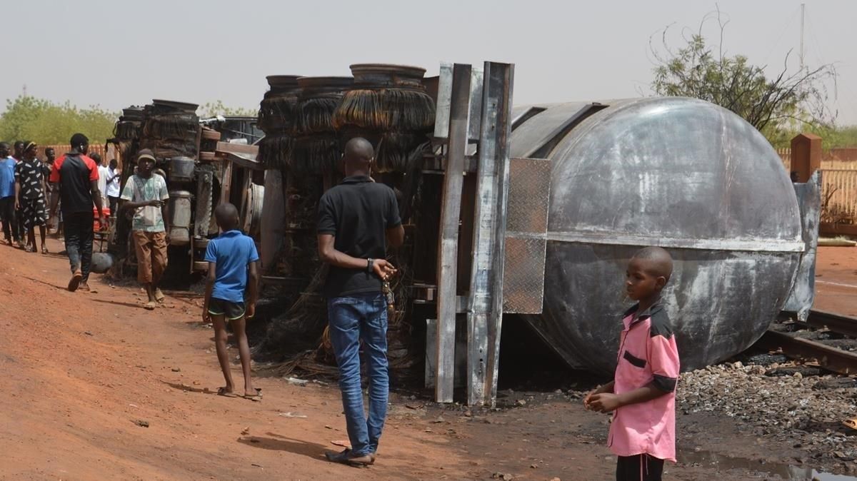 Un grupo de personas junto al tanque de combustible que estalló y mató a al menos 58 vecinos cerca del aeropuerto de Niamey. Un grupo de personas junto al tanque de combustible que estalló y mató a al menos 58 vecinos cerca del aeropuerto de Niamey.