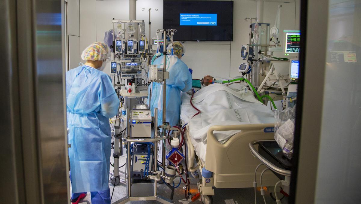  Un sanitario asiste a un enfermo de covid-19, en la uci del Hospital Clínic de Barcelona.