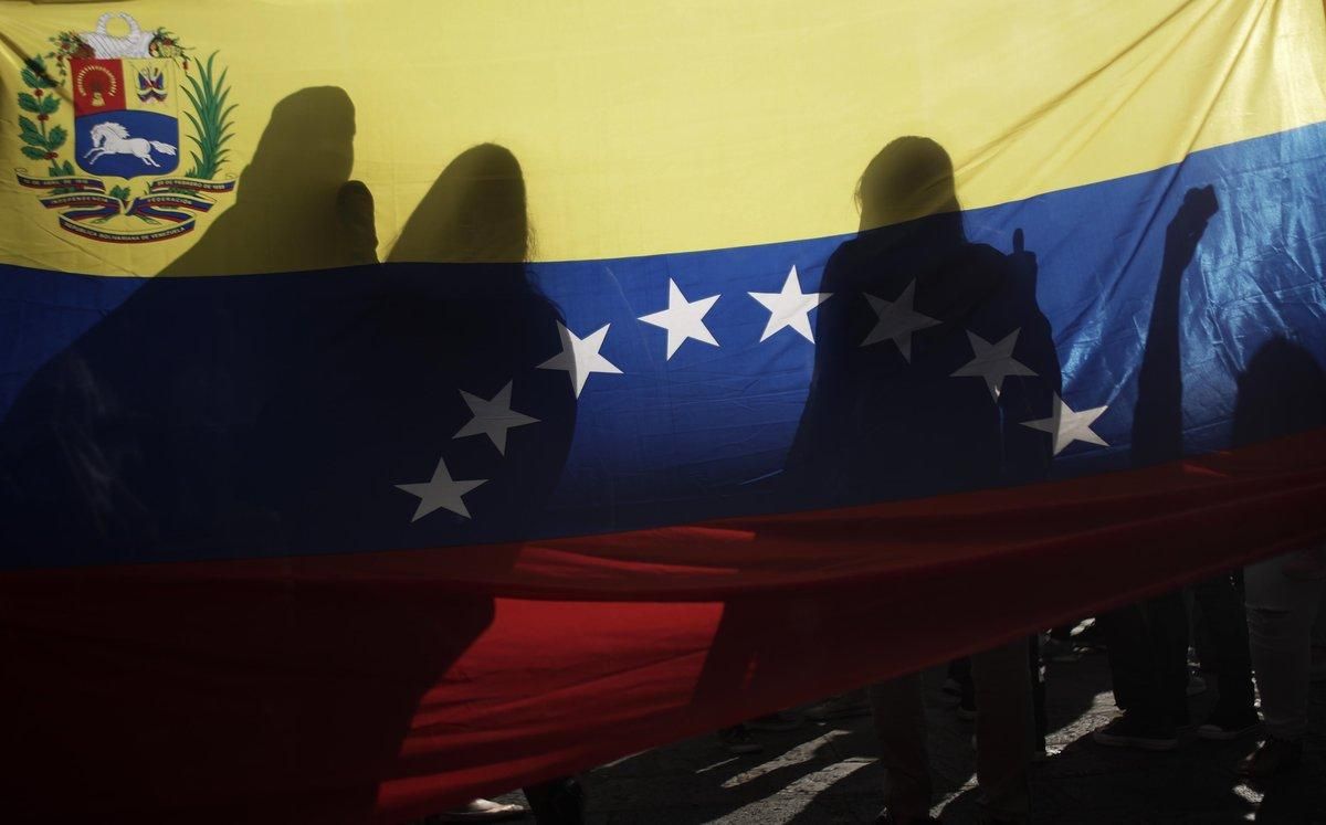 La bandera venezolana, entre sombras en una protesta en Costa Rica. La bandera venezolana, entre sombras en una protesta en Costa Rica.