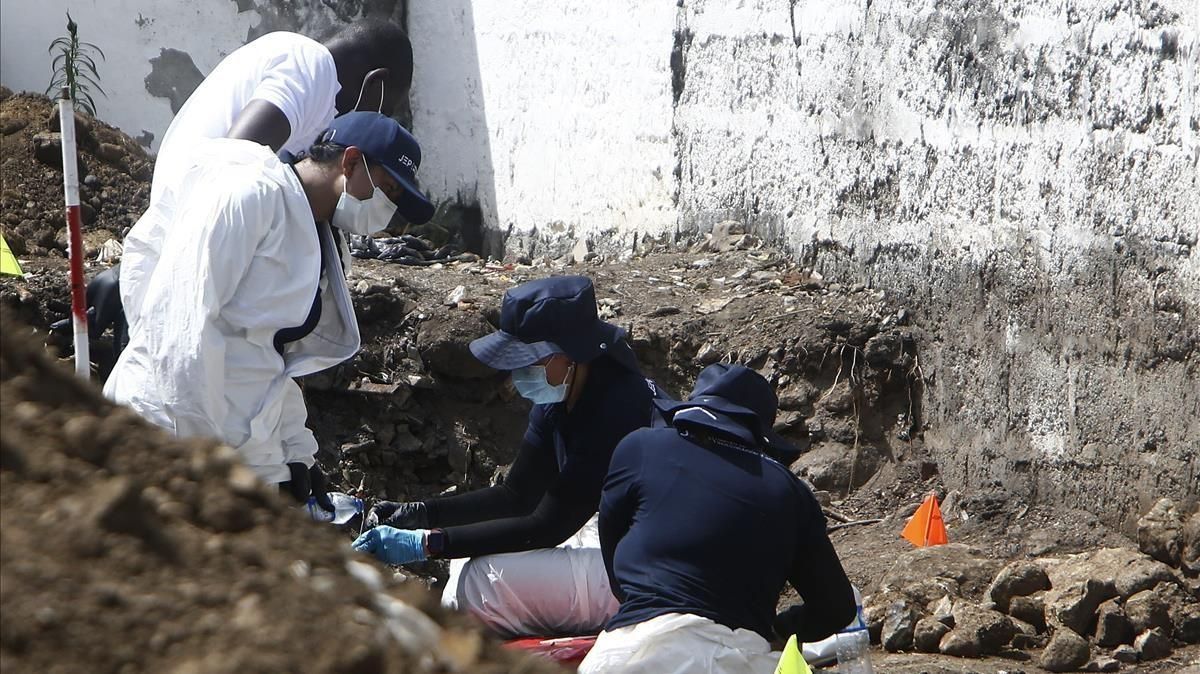 Expertos forenses de la JEP llevan a cabo labores de exhumación en el cementerio de Dabeiba, en el noroccidente de Colombia, en una fosa común donde fueron hallados restos de víctimas de los ’falsos positivos’. Expertos forenses de la JEP llevan a cabo labores de exhumación en el cementerio de Dabeiba, en el noroccidente de Colombia, en una fosa común donde fueron hallados restos de víctimas de los ’falsos positivos’.