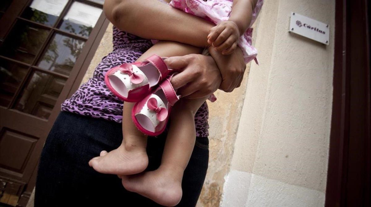 Una madre, junto a su hija, en el centro maternoinfantil de Cáritas en Badalona. Una madre, junto a su hija, en el centro maternoinfantil de Cáritas en Badalona.