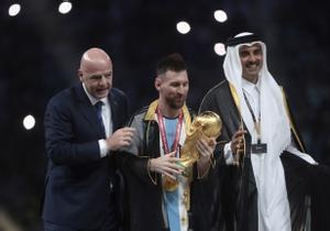 Lionel Messi, ataviado con la prenda del emir, posa con el trofeo de la Copa del Mundo junto a el presidente de la FIFA Giovanni Vincenzo y el emir de Qatar.