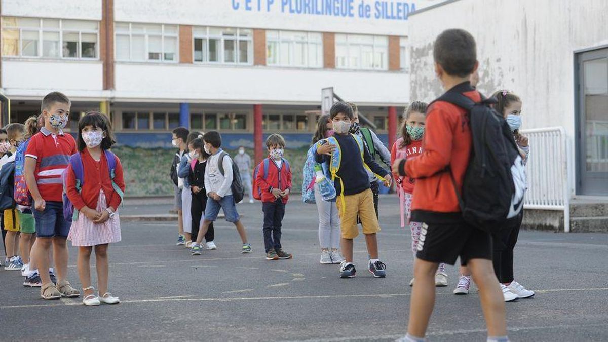 Niños con mascarilla en el patio de un colegio. Niños con mascarilla en el patio de un colegio.