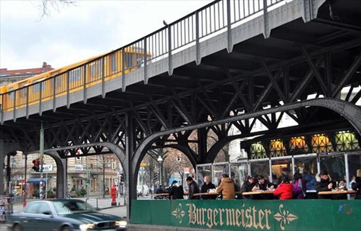 El Burgermeister ha fet de la seva particular ubicació i del seu greixós menú les claus d’un èxit inesperat: llargues cues de berlinesos esperen per aconseguir taula. El Burgermeister ha fet de la seva particular ubicació i del seu greixós menú les claus d’un èxit inesperat: llargues cues de berlinesos esperen per aconseguir taula.