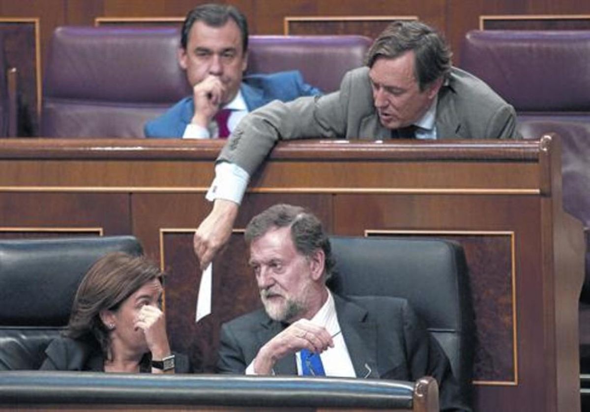 Mariano Rajoy y Soraya Sáenz de Santamaría hablan en el banco azul mientras Rafael Hernando les pasa una nota. Mariano Rajoy y Soraya Sáenz de Santamaría hablan en el banco azul mientras Rafael Hernando les pasa una nota.
