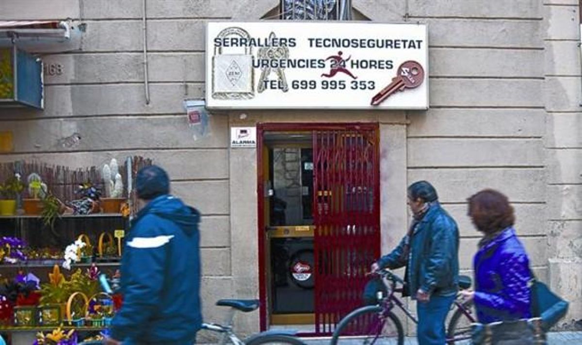 Unos viandantes pasan por delante de la cerrajería de los dos detenidos, ayer. Unos viandantes pasan por delante de la cerrajería de los dos detenidos, ayer.