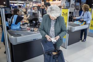 Una mujer mira su ticket de compra en un supermercado de Barcelona.
