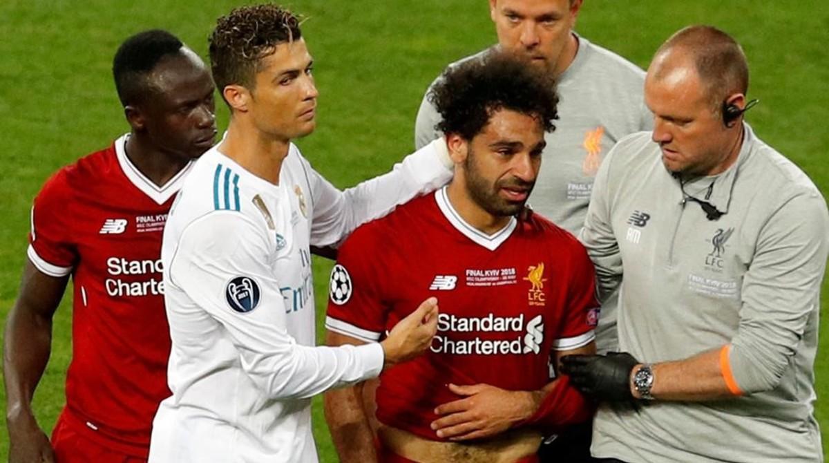 Salah abandona el estadio de Kiev tras la agresión de Ramos. Le consuela Cristiano. Salah abandona el estadio de Kiev tras la agresión de Ramos. Le consuela Cristiano.